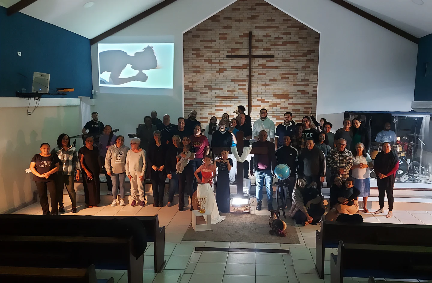 Grupo da igreja reunido diante da cruz